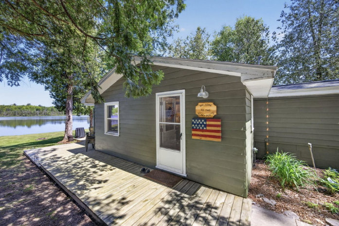 Exterior of the cottage with deck and lake to the side