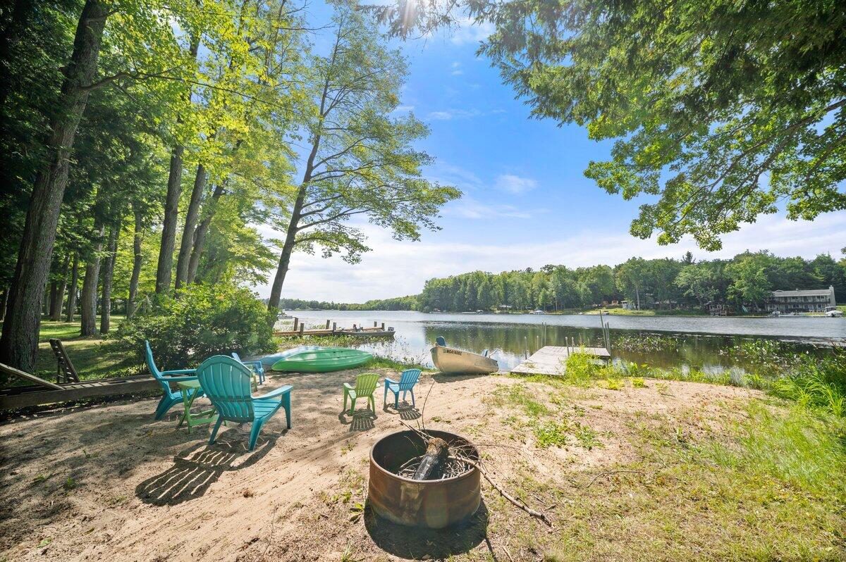 Sand shoreline with chairs, a fire pit and a dock on Diamond Lake at 20308 Lakeview Drive